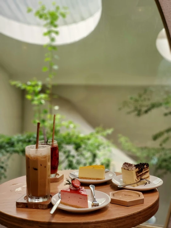 a table with desserts and drinks on it, a picture, by Tan Ting-pho, unsplash, photorealism, atrium, brown, cake, thumbnail