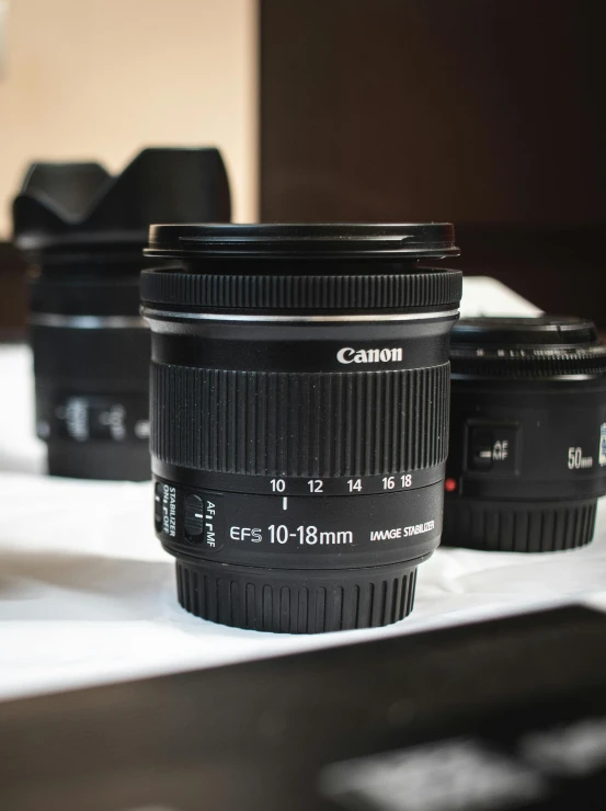 a group of cameras sitting on top of a table, a picture, by Robbie Trevino, canon macro lens, close up wide angle lens, medium wide front shot, ultra wide 1 0 mm