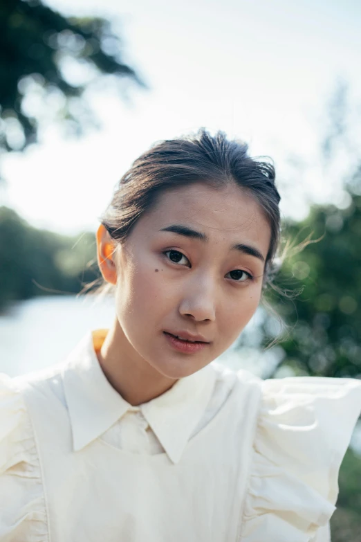 a woman standing in front of a body of water, trending on pexels, shin hanga, wearing a white button up shirt, li bingbing, headshot, sydney park