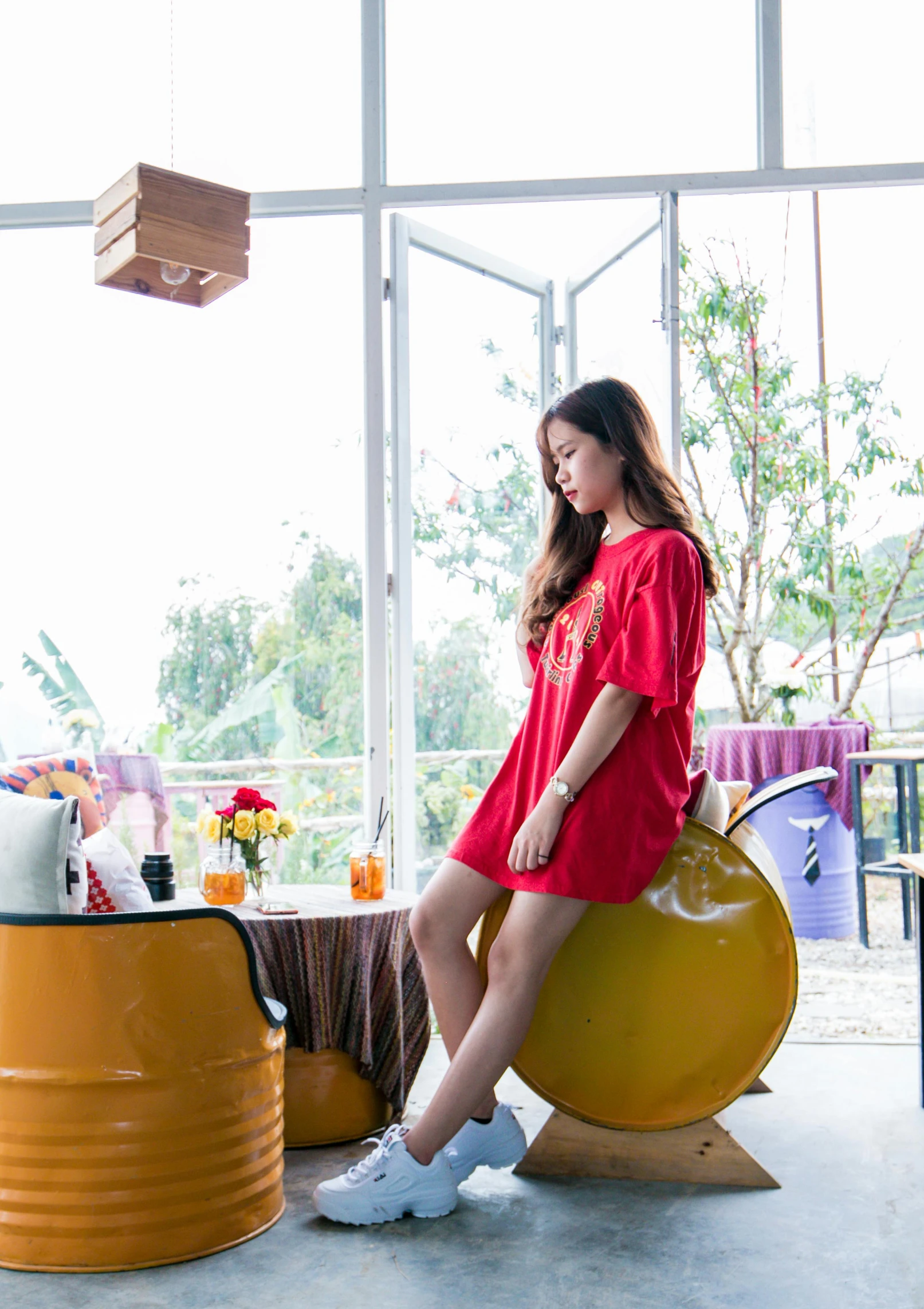 a woman in a red dress sitting on a yellow barrel, unsplash, happening, in tshirt, ulzzang, in house, dang my linh