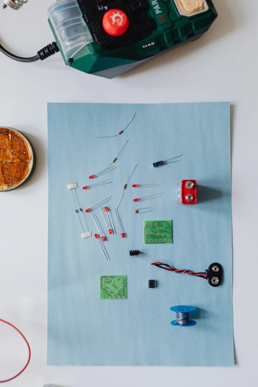 a piece of paper sitting on top of a table, by Will Ellis, kinetic art, with sparking circuits, flatlay, childhood, pins