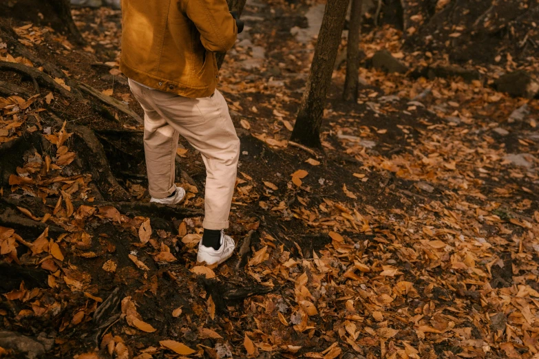 a man standing in the woods holding an umbrella, pexels contest winner, brown pants, wearing white sneakers, golden leaves, thumbnail