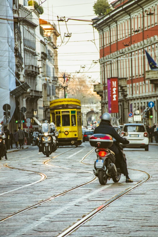 a man riding on the back of a motorcycle down a street, by Anita Malfatti, pexels contest winner, renaissance, trams, square, 🚿🗝📝