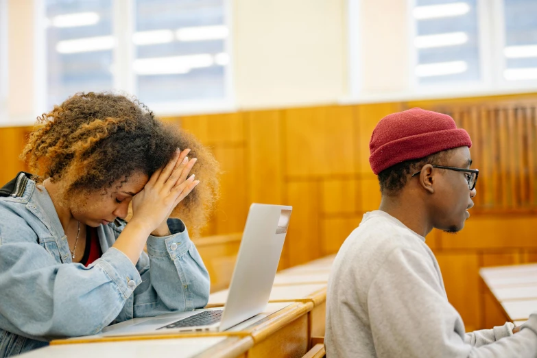 a couple of people that are sitting in front of laptops, trending on pexels, academic art, facepalm, an ahoge stands up on her head, sitting in the classroom, photo of a black woman