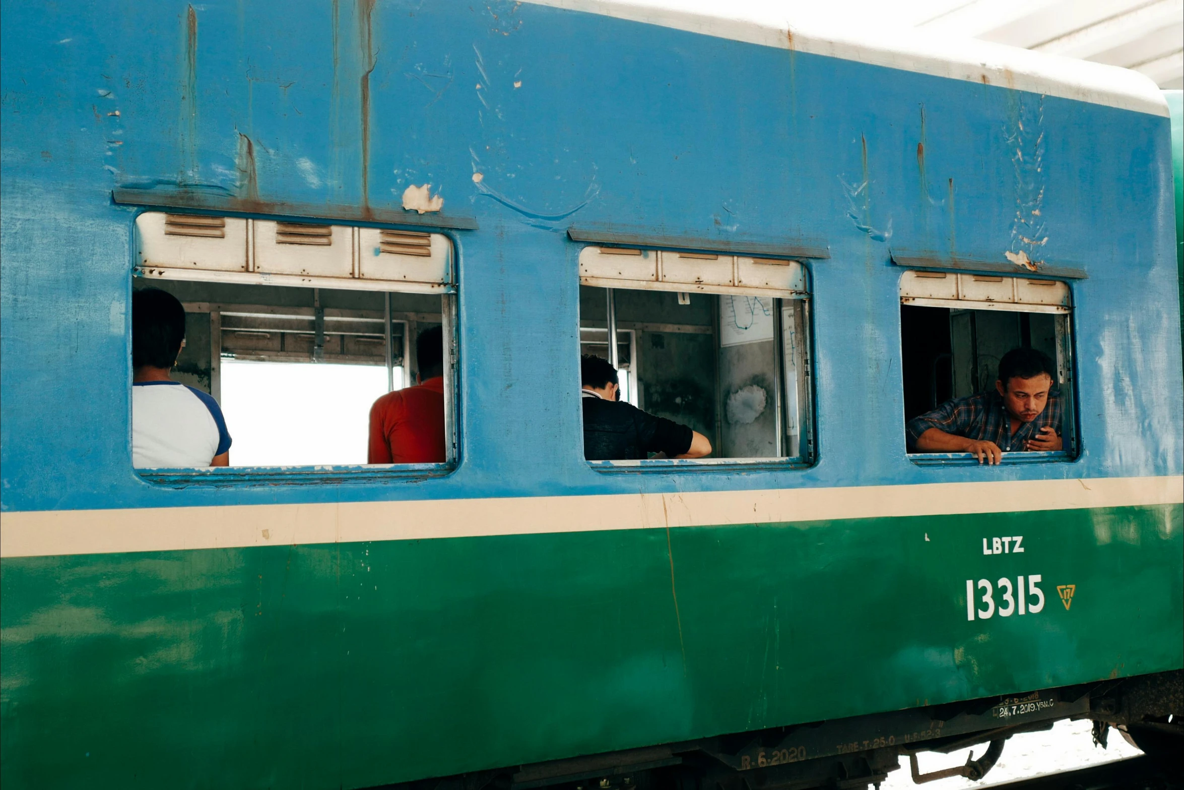 a group of people looking out the window of a train, hurufiyya, blue and green, square, bao phan, 2022 photograph