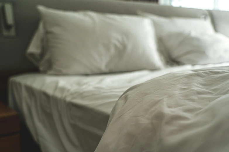a bed is covered with white linens