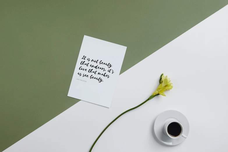 a note sitting on top of a table next to a cup of coffee, inspired by Zsolt Bodoni, unsplash, minimalism, photographic print, beauty campaign, inspirational quote, ilustration