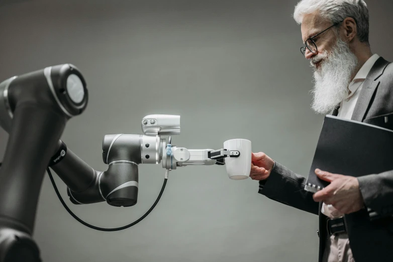 a man standing next to a robot holding a folder, by Adam Marczyński, unsplash, renaissance, old man doing with mask, prosthetic arm, reaching out to each other, gray men