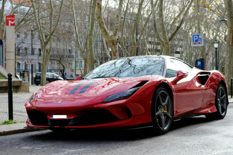 a red sports car on the road near trees