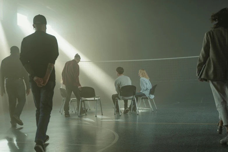 a group of people that are standing in a room, by Elsa Bleda, pexels contest winner, hyperrealism, volley court background, 3 actors on stage, man sitting facing away, volumetric lighting and fog