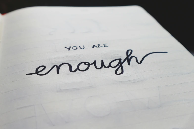 a sketch book that is opened with handwriting and the words you are enough