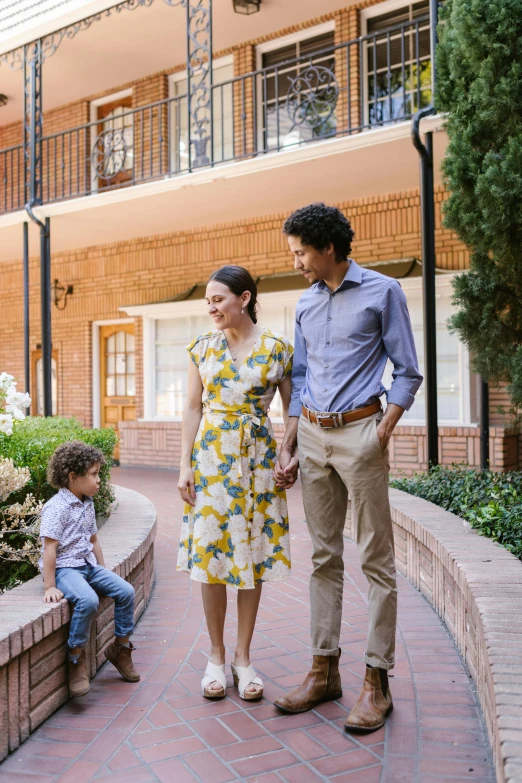 a couple of people that are standing in front of a building, courtyard walkway, family friendly, hotel, toddler