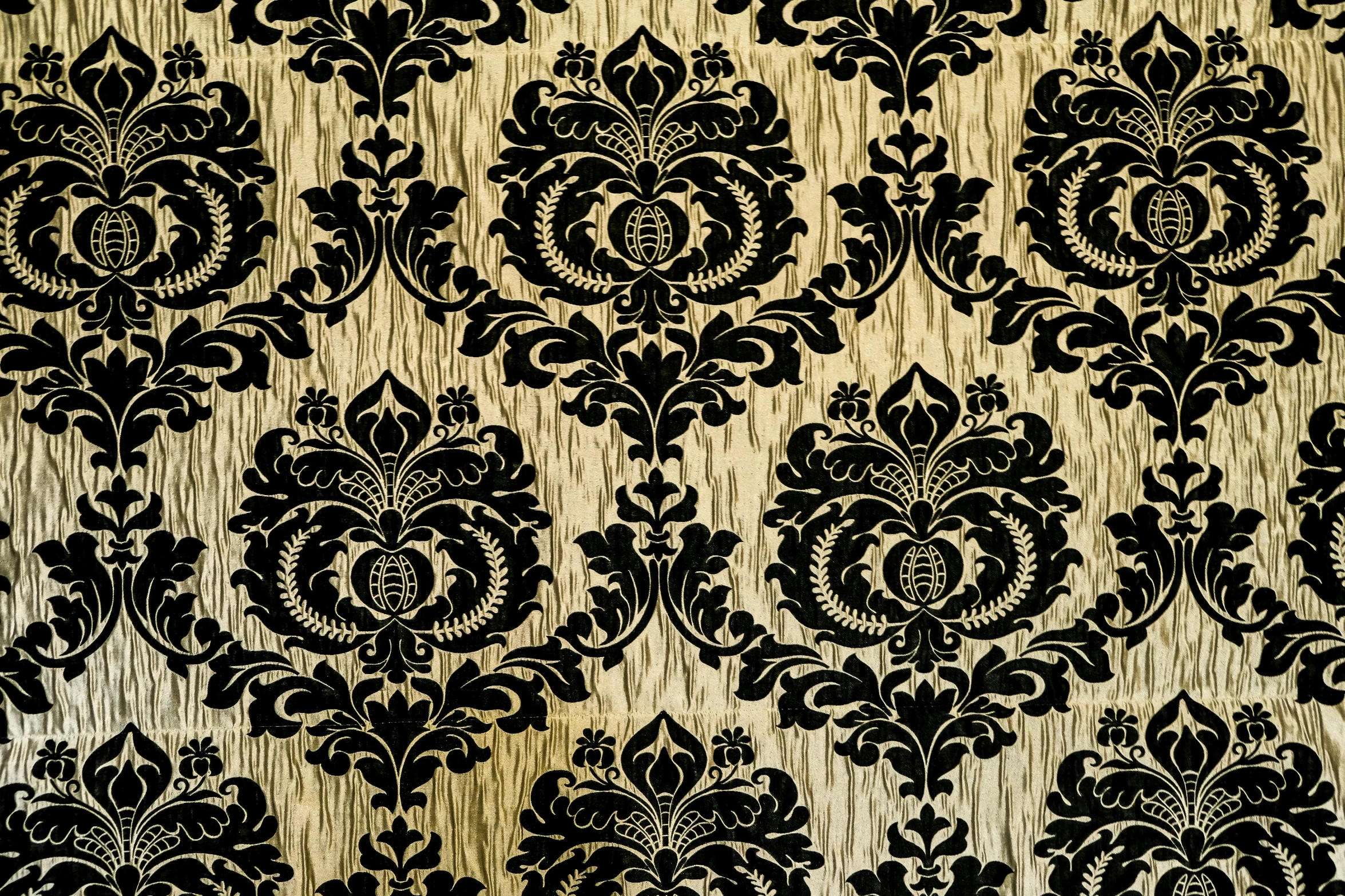 a close up of a black and gold wallpaper, background made of big curtains, pale yellow wallpaper, on a velvet tablecloth, ornate wood