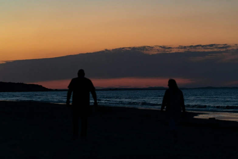 two people walking on a beach at sunset, a picture, by Mathias Kollros, 8k 50mm iso 10, silhouette :7, fan favorite, night photo