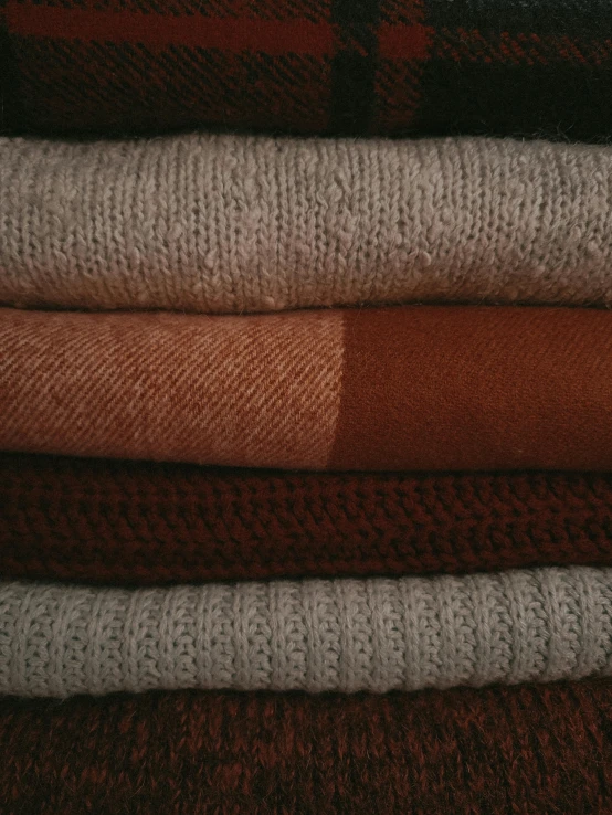 a stack of sweaters stacked on top of each other, inspired by Toss Woollaston, unsplash, renaissance, burnt sienna, ignant, medium close - up ( mcu ), witchy clothing