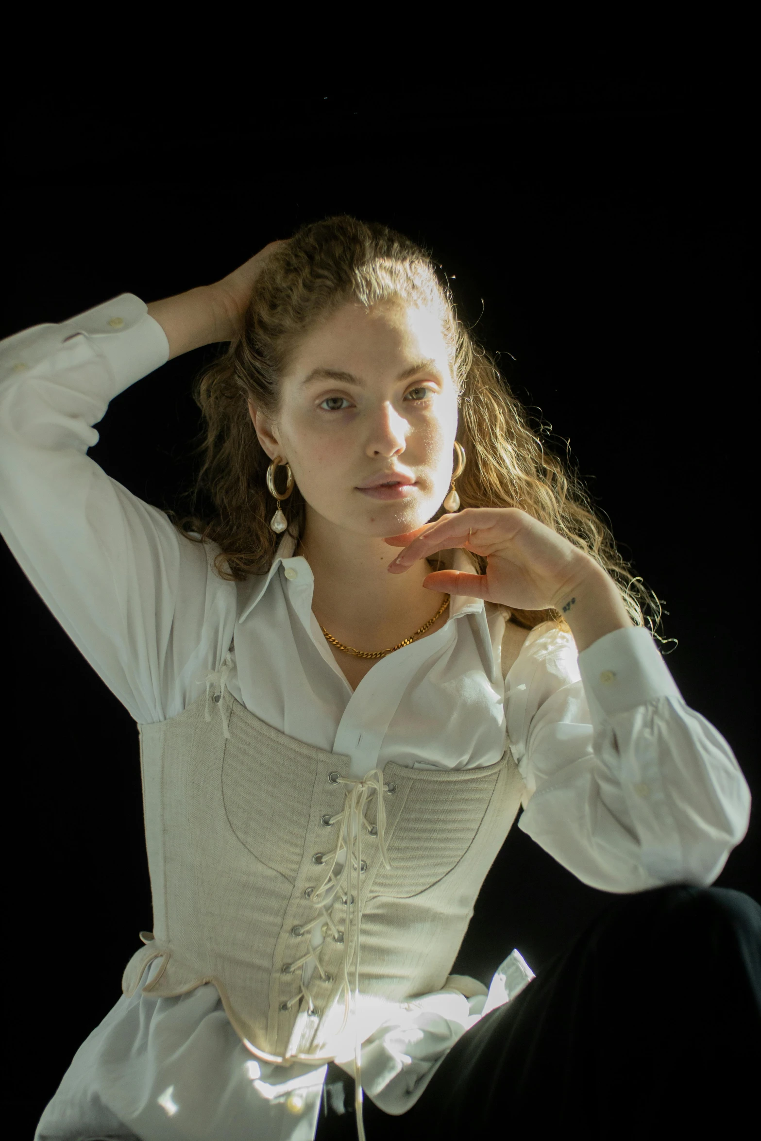 a woman in a white shirt and black pants, an album cover, inspired by Anna Füssli, renaissance, portrait sophie mudd, wearing 1890s era clothes, with a black background, curly blonde hair | d & d