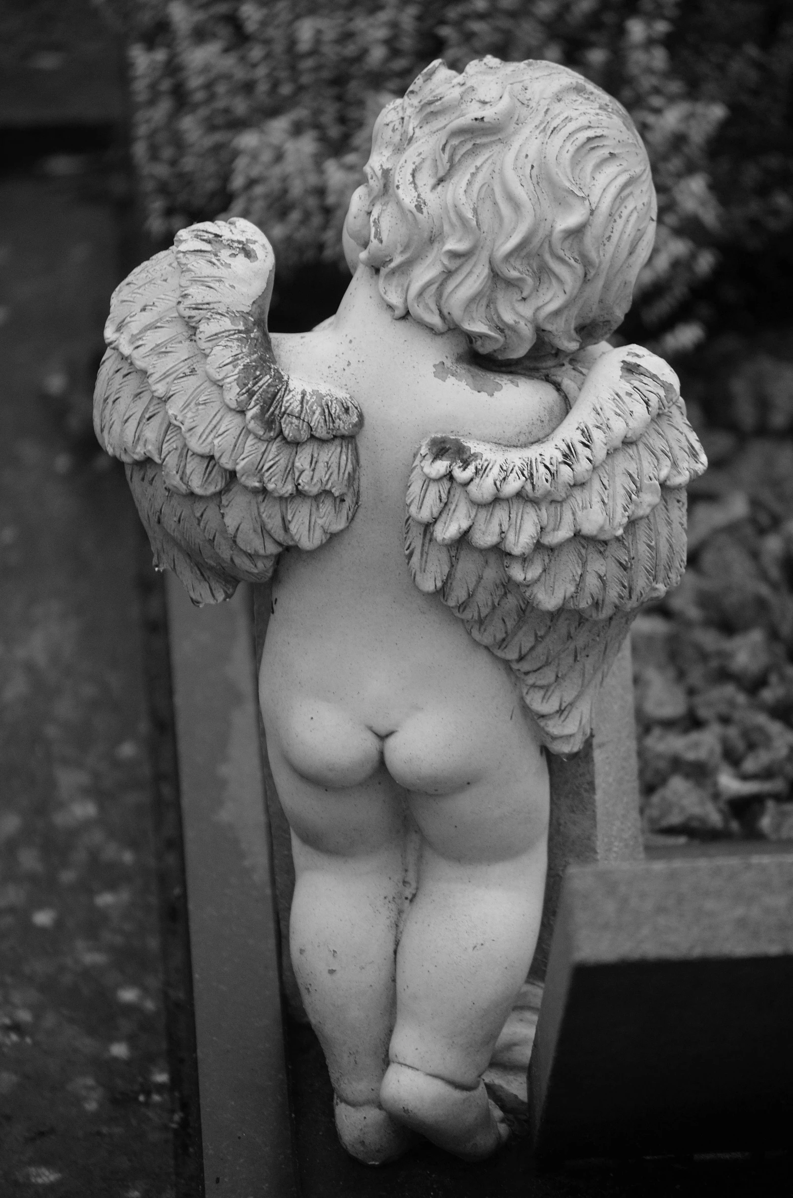 a statue of an angel sitting on a bench, by Marie Angel, nsfw, top down view, back and white, cherub