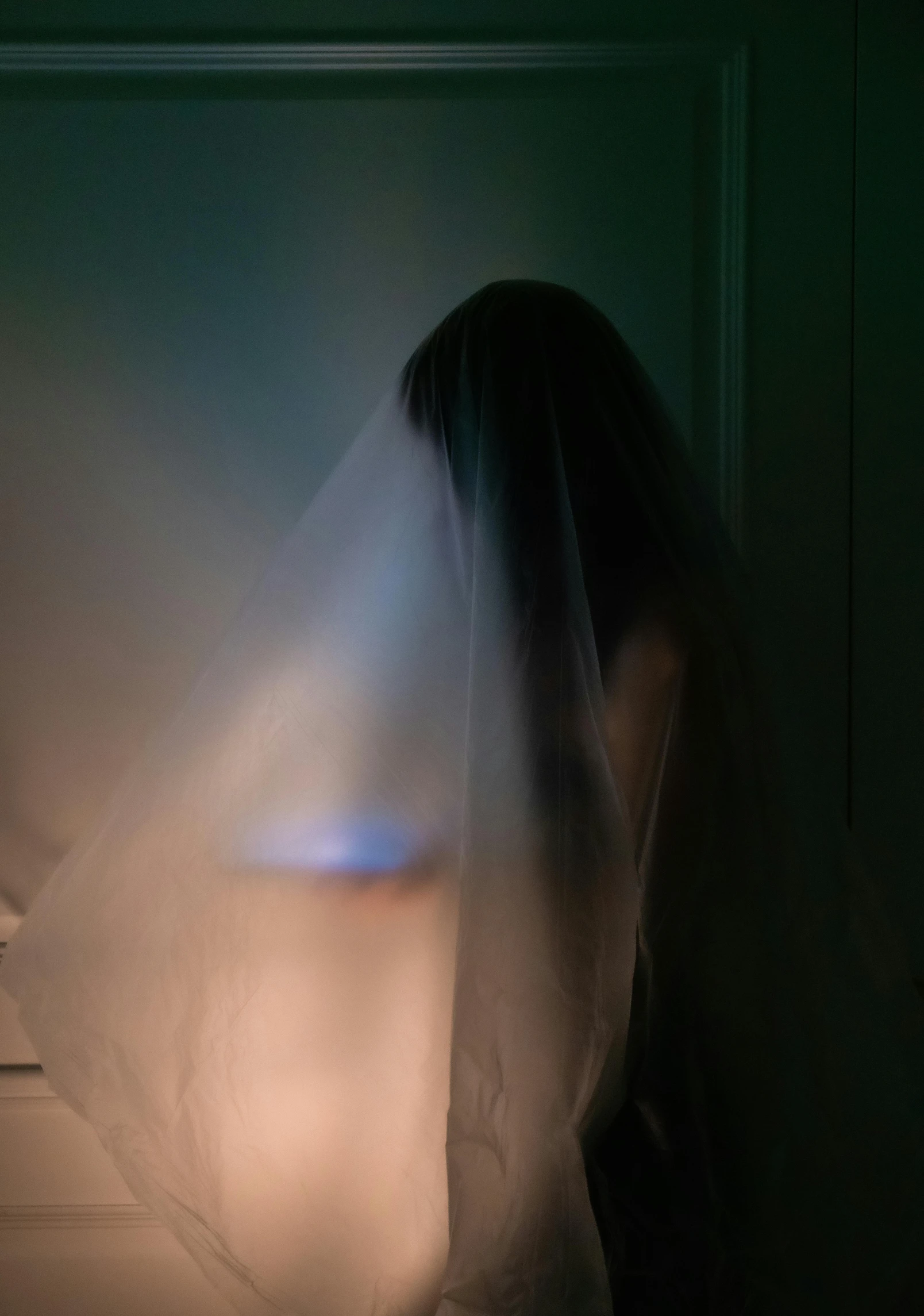 a woman standing in a dark room with a veil over her head, a hologram, inspired by Elsa Bleda, light haze, ring lit, ignant, halloween ghost under a sheet