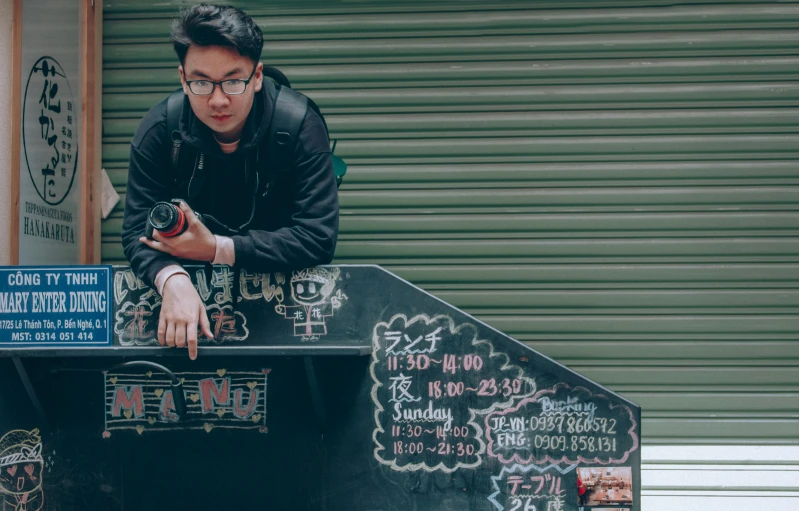 a man standing on top of a skateboard ramp, an album cover, inspired by Liam Wong, pexels contest winner, graffiti, stood outside a corner shop, holding polaroid camera, handsome chad chin, 15081959 21121991 01012000 4k