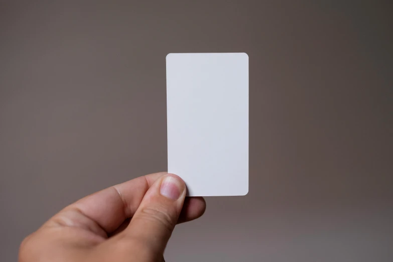 a person holding a white card in their hand, by Adam Pijnacker, unsplash, glossy white metal, straight smooth vertical, rpg item, 4 k smooth