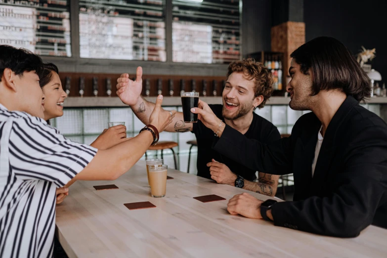 a group of men sitting around a wooden table, by Carey Morris, pexels contest winner, holding a drink, aussie baristas, cheers, avatar image