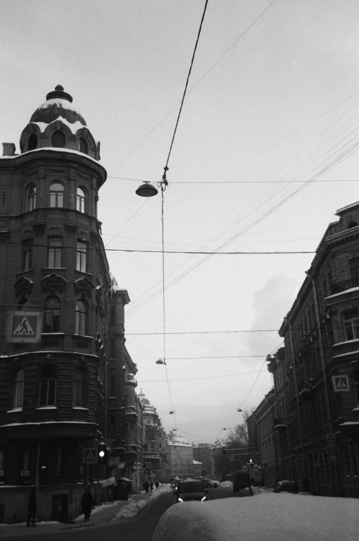 a black and white photo of a city street, a black and white photo, viennese actionism, electric cables, siberia!!, winter vibes, victorian buildings