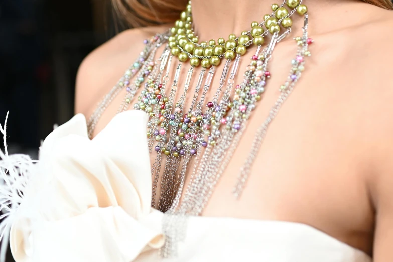 a close up of a woman wearing a necklace and earrings, inspired by Perle Fine, trending on pexels, maximalist fashion dress, thumbnail, draped in fleshy green and pink, jessica alba