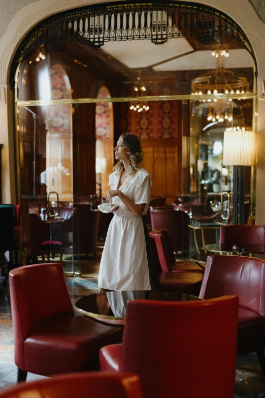 a woman in a long white dress is eating