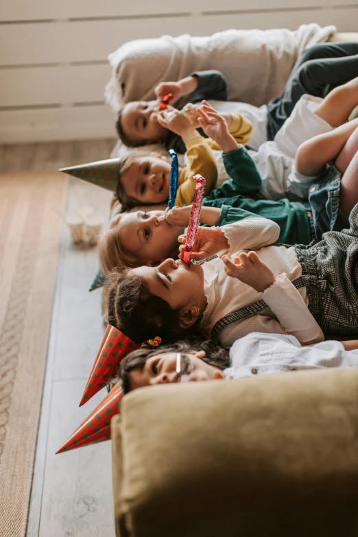 a group of children laying on top of a couch, by Nina Hamnett, pexels contest winner, at a birthday party, holding maracas, hygge, profile image