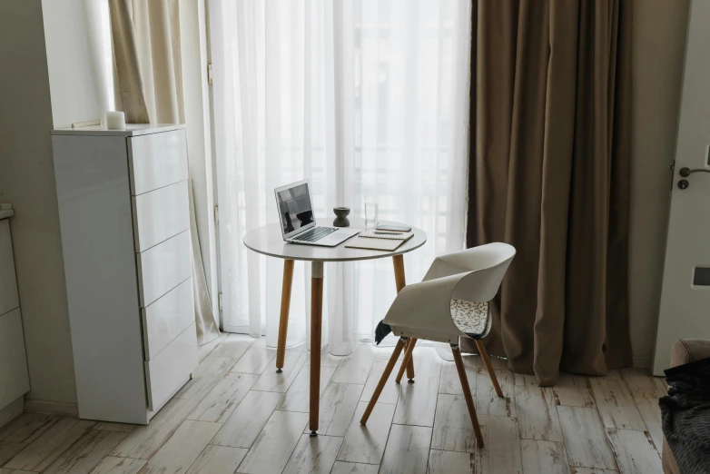 a white table and chair in front of a window