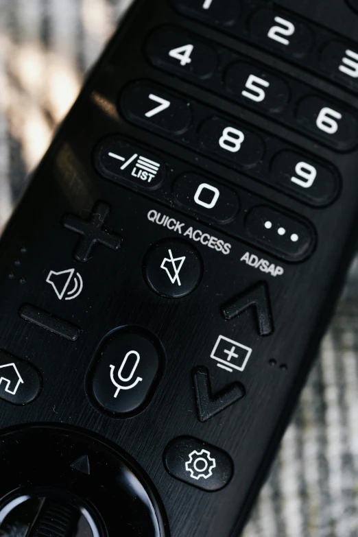 a close up of a remote control on a table, unsplash, multiple stories, symbols, panel of black, taken with sony alpha 9