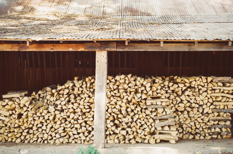 a pile of wood sitting in front of a building, by Carey Morris, unsplash, inside a shed, dwell, birch, woodfired