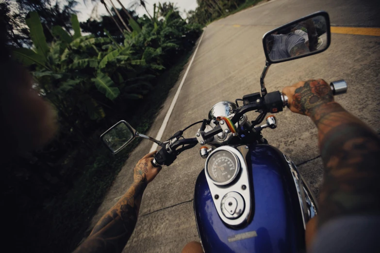 a motorcyclist is seen from the seat of his vehicle on a rural road