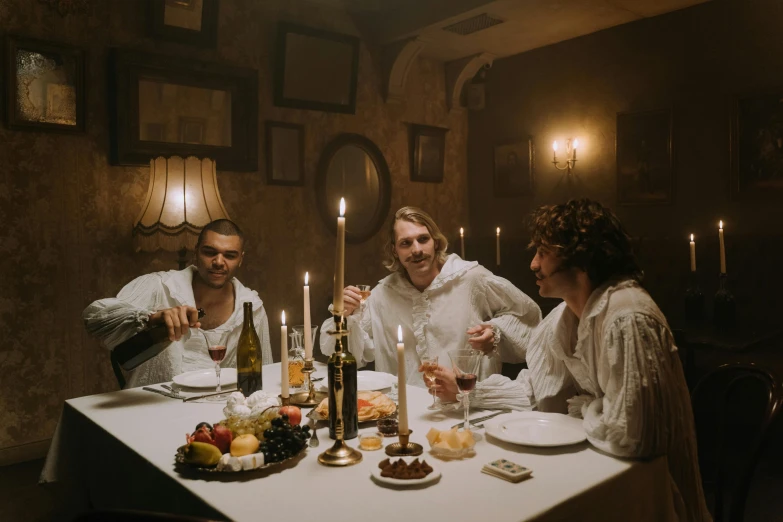 three people sitting at the table drinking wine