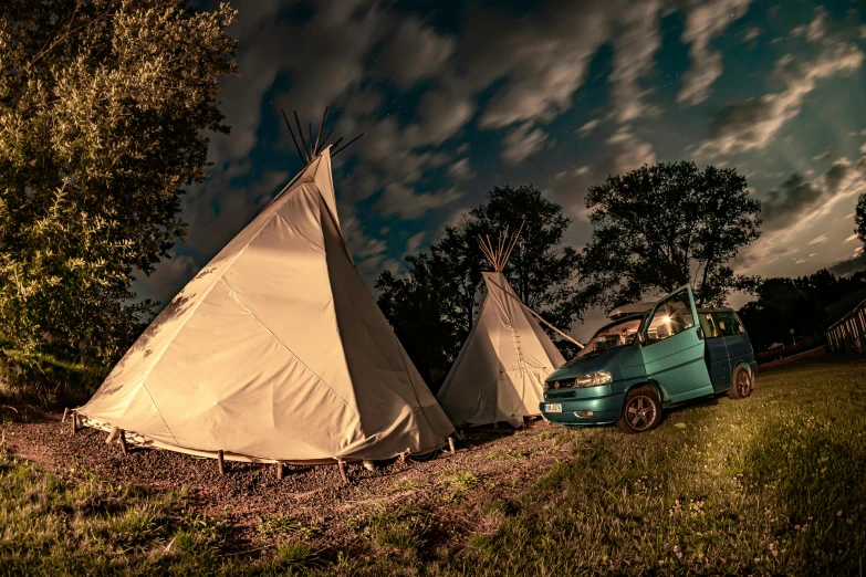 a couple of tents sitting on top of a lush green field, by Thomas Häfner, graffiti, cinematic lighting at night, teepee, kombi, artisanal art