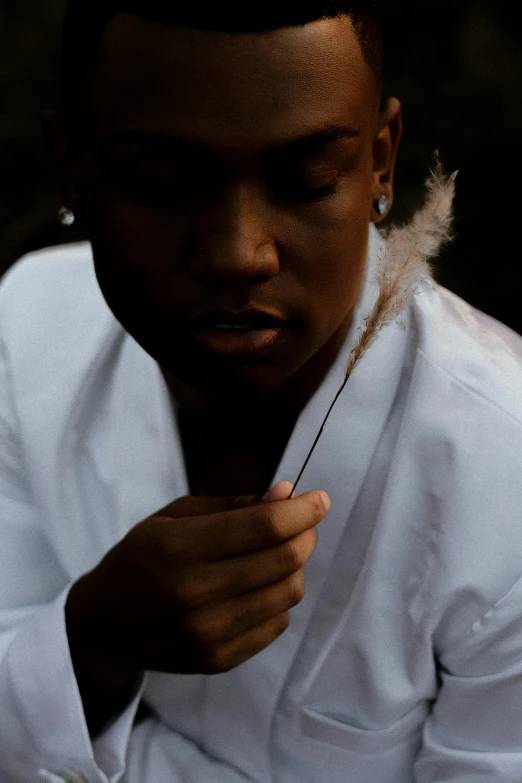 a man with feathers on his head is holding his tie in his hand