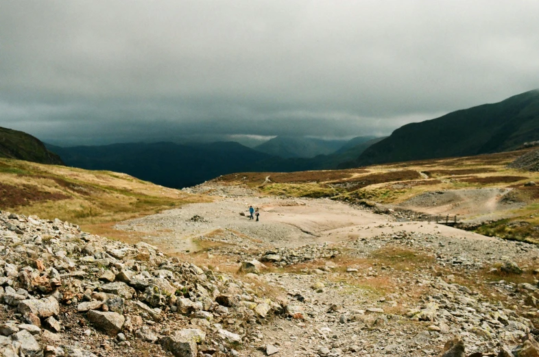 two people on a rocky trail in the mountains