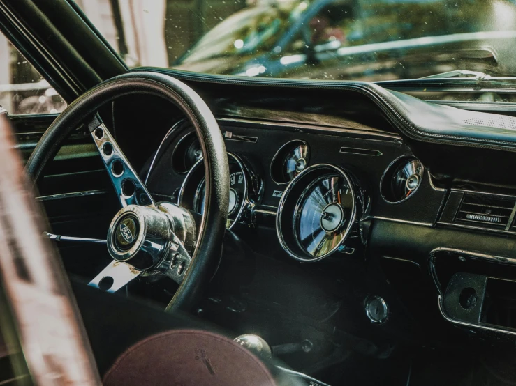 a close up of a steering wheel and dashboard of a car, by Adam Marczyński, pexels contest winner, photorealism, mustang, casually dressed, profile image, old color photograph