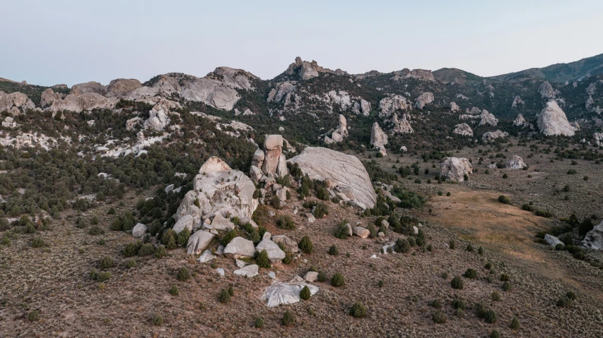 several rocky mountains with green brush growing on the hill sides