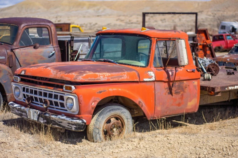 an old rusted truck sitting in the middle of a field, a colorized photo, unsplash, photorealism, red and orange colored, parked cars, high cheek bones, ford