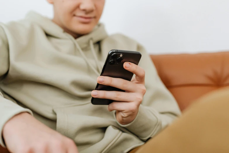 a man in a gray hoodie using his cellphone