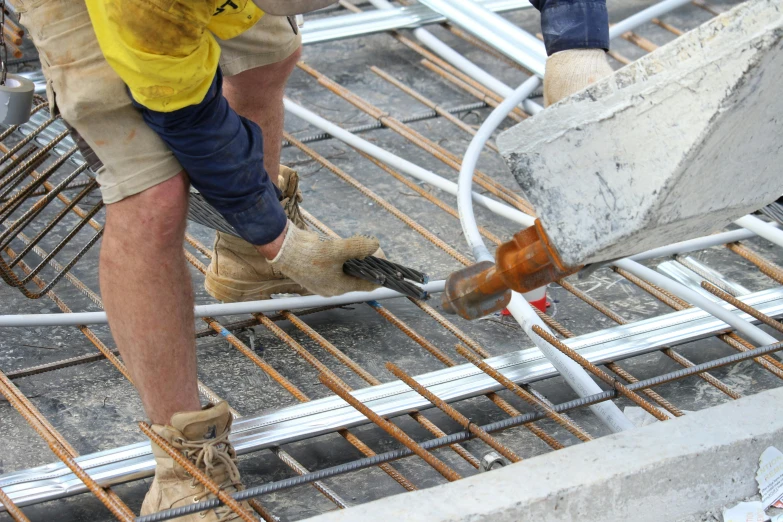 a close up of a person on a construction site, hoses, white concrete floor, steel studs, graeme base