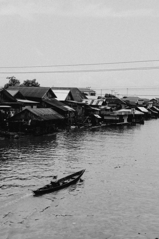 a black and white photo of a body of water, by Yosa Buson, quaint village, bangkok, makeshift houses, on a boat