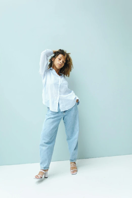 a child stands in front of a blue wall with a white top