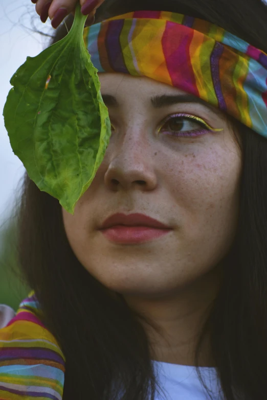 a close up of a person holding a leaf, an album cover, inspired by Elsa Bleda, pexels contest winner, renaissance, young beautiful hippie girl, colorful eyes, avatar image, cottage hippie naturalist