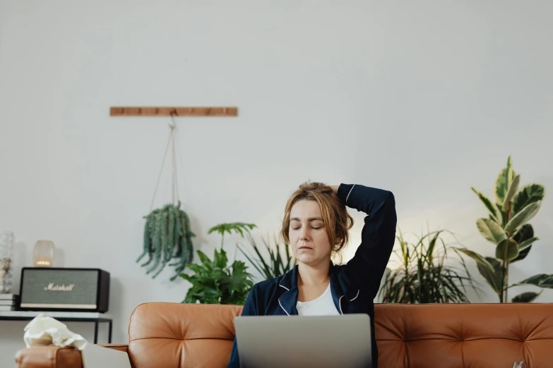 a woman sitting on a couch using a laptop, trending on pexels, figuration libre, bend over posture, people at work, laying down, pictured from the shoulders up