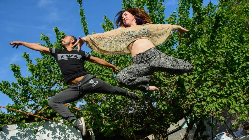 a man flying through the air while riding a skateboard, arabesque, a woman floats in midair, avatar image, hila klein, outdoor rave