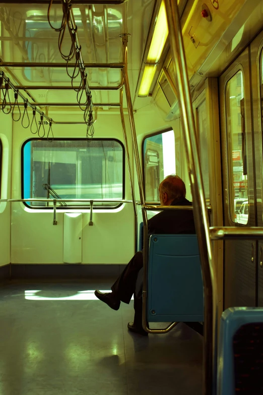 a person sitting on a train looking out the window, postminimalism, cyan and gold scheme, trams ) ) ), seattle, underground metro