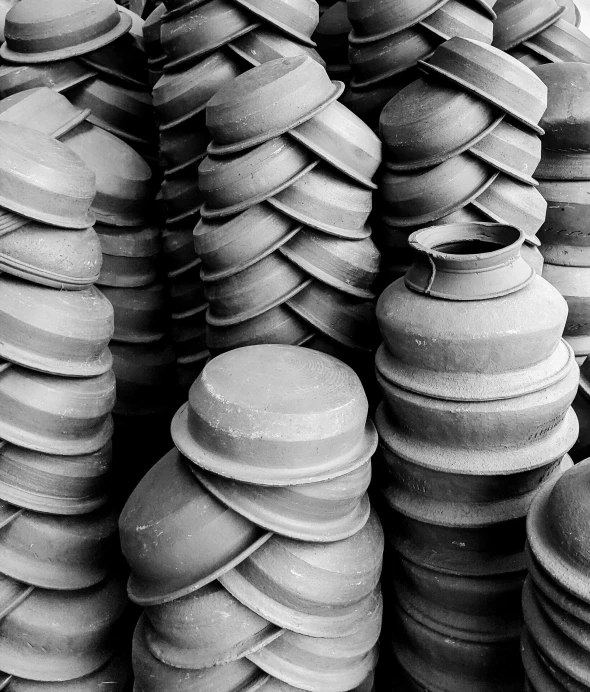 a bunch of clay pots stacked on top of each other, a black and white photo, mingei, machineparts, smooth rounded shapes, photograph credit: ap, the vibrant echoes of the market