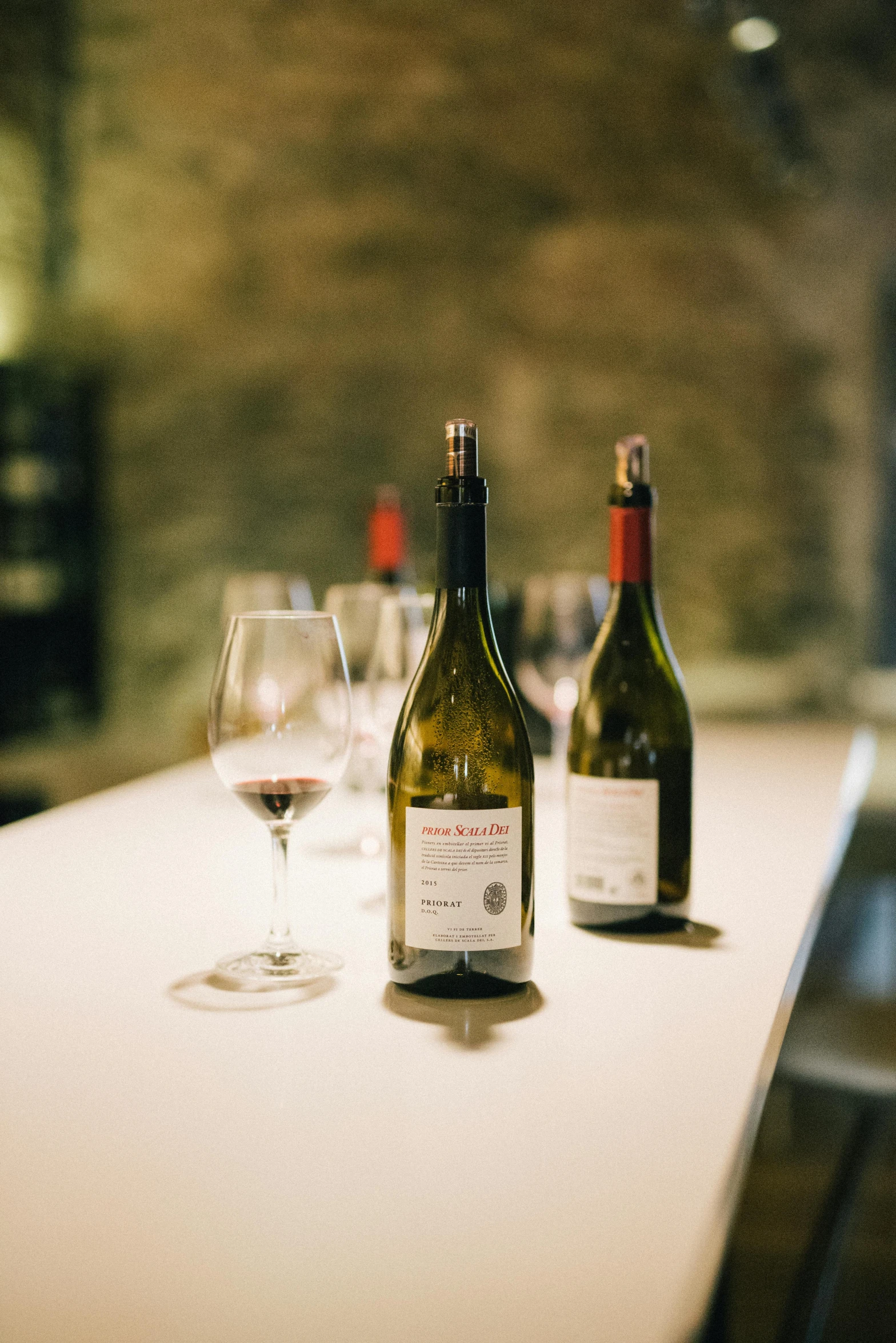 two bottles of wine on a table with glass of wine